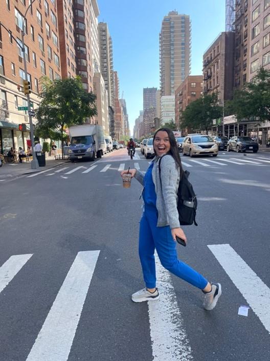 YLC member Hilary walking across a crosswalk and smiling