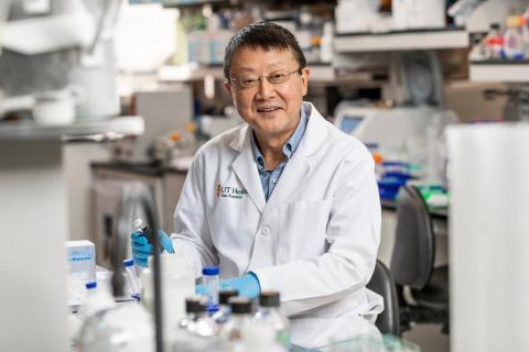 Scientist smiling for the camera while working in the lab