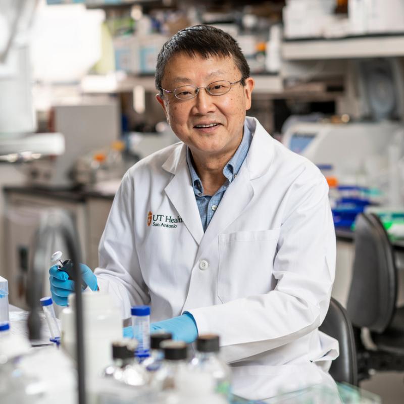 Scientist smiling for the camera while working in the lab