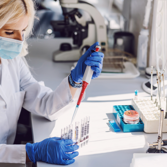 Scientist performing research with pipette and test tubes in the lab